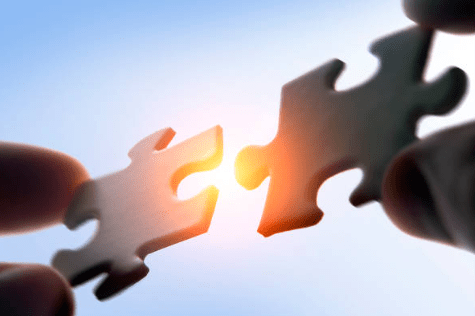 Two puzzle pieces joining each other.